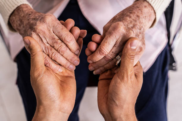 Close-up of a caregiver gently holding the hands of an older adult, symbolizing compassionate home health care in Scottsdale 85260.
