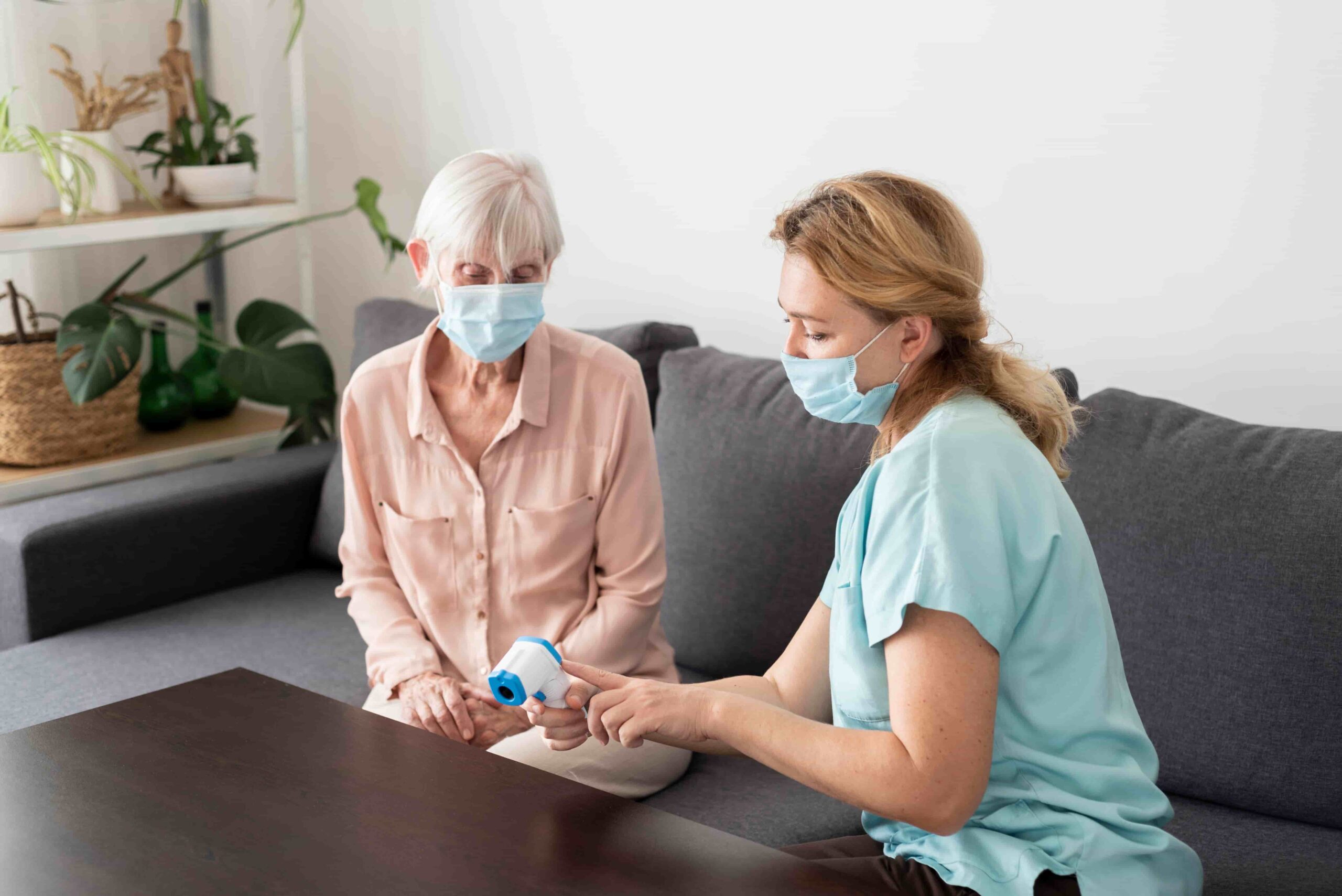 Home medical care provided to Vi at Grayhawk residents by Dr. Cook’s team Female nurse providing in-home care to an older adult wearing masks for safety.