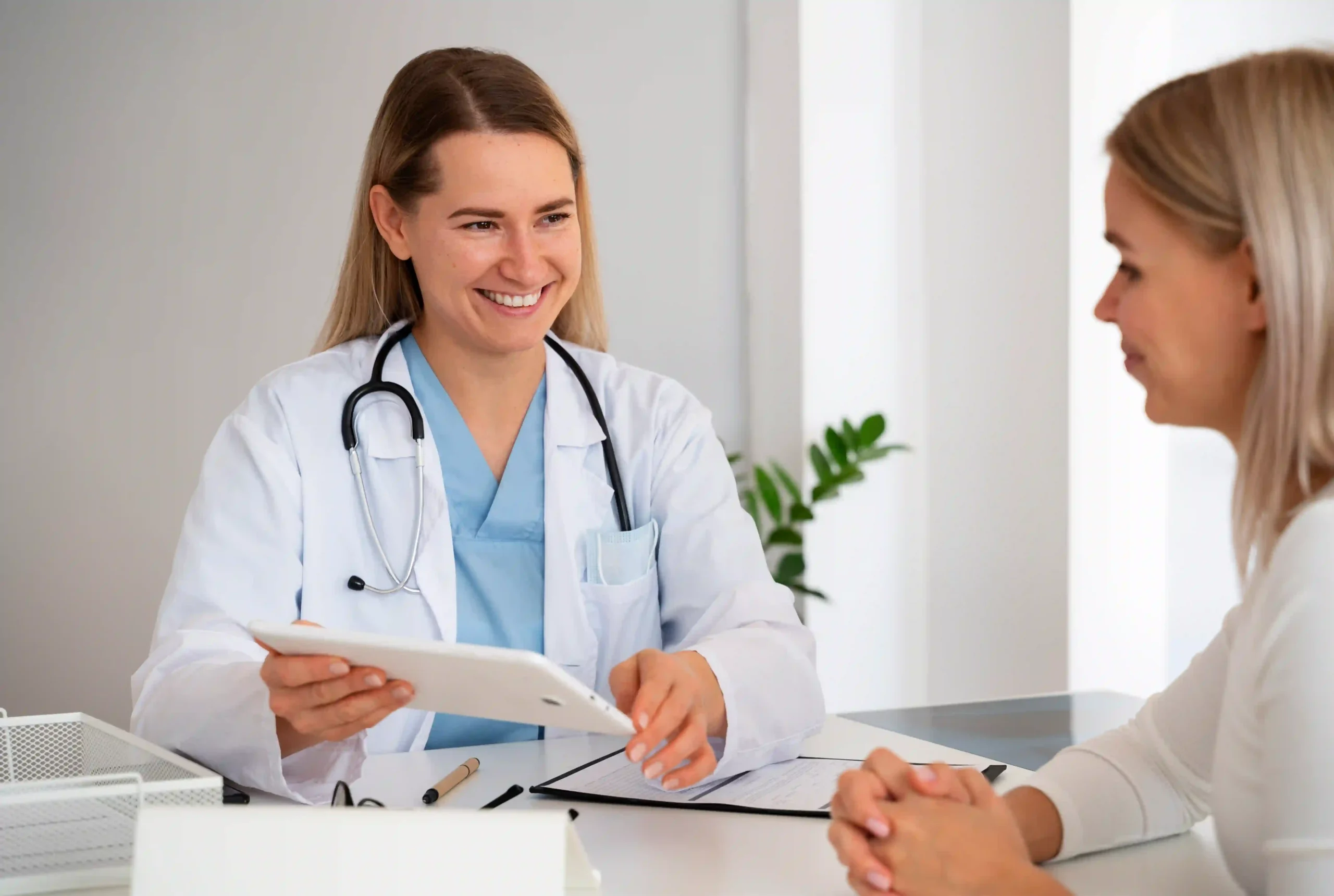 Smiling young female doctor talking to a patient during a consultation in a modern medical office
