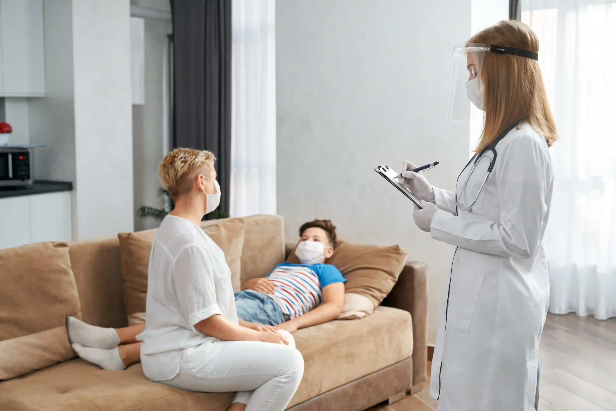 Female doctor conducting a home visit, assessing a sick child while the mother looks on with concern
