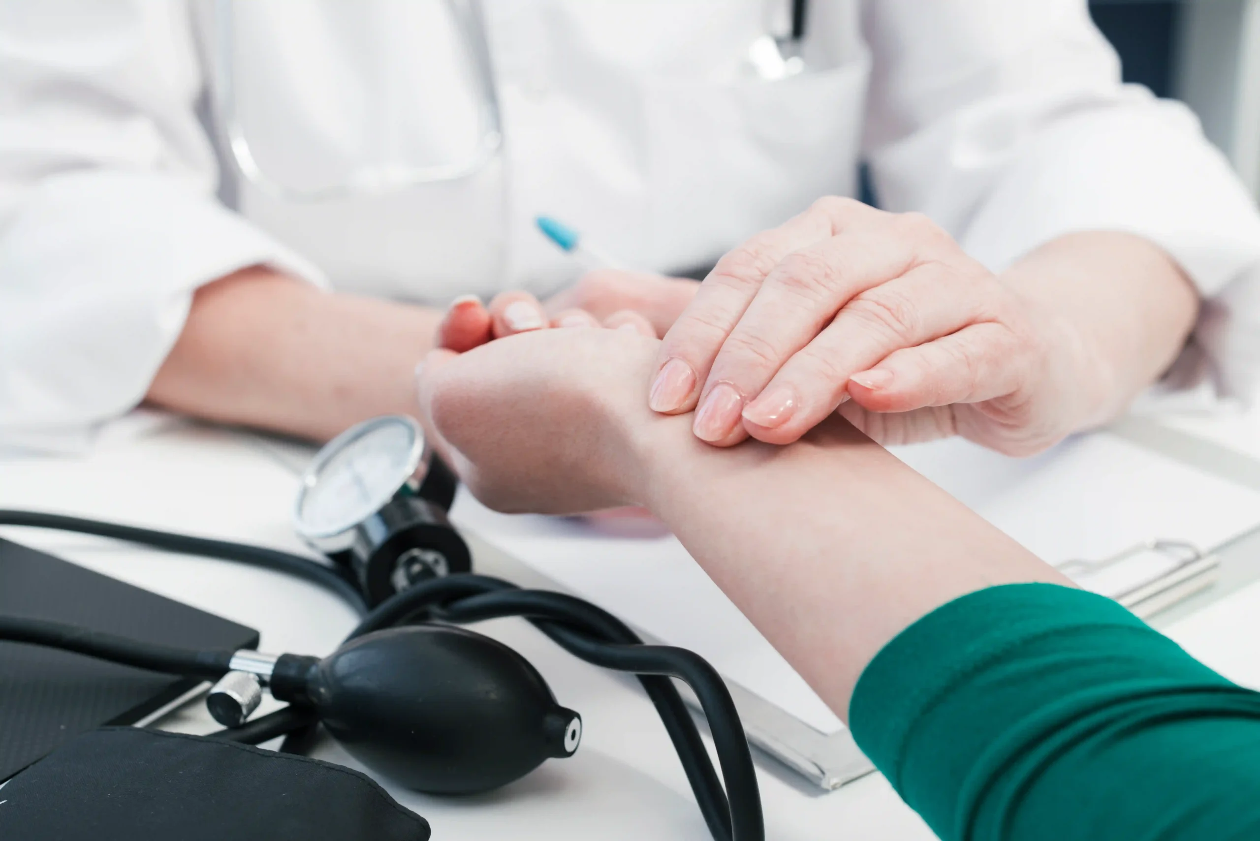 Close-up of doctor checking patient’s pulse during routine health examination.