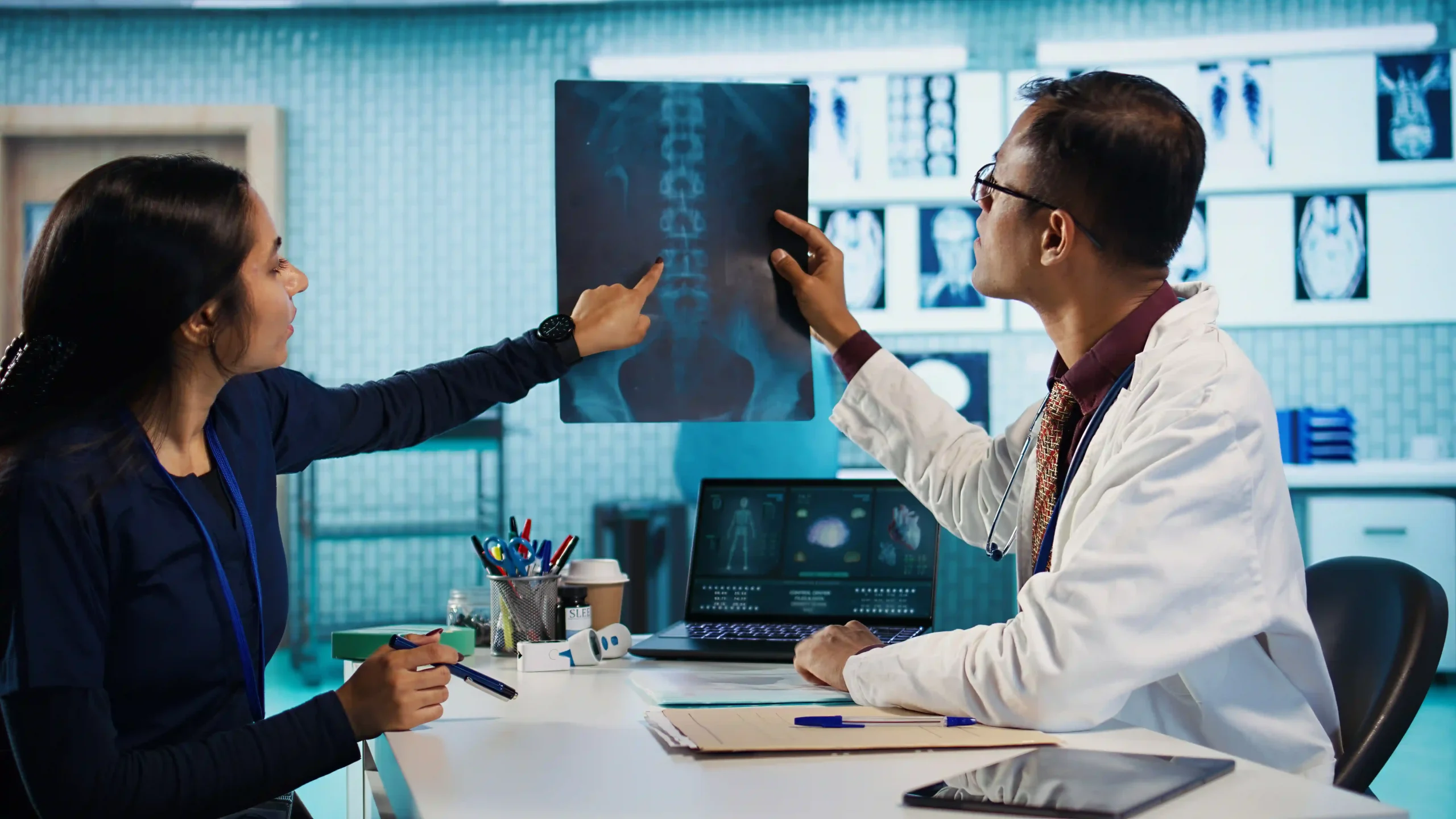 Doctor and nurse discussing spinal X-ray results in a modern clinic.