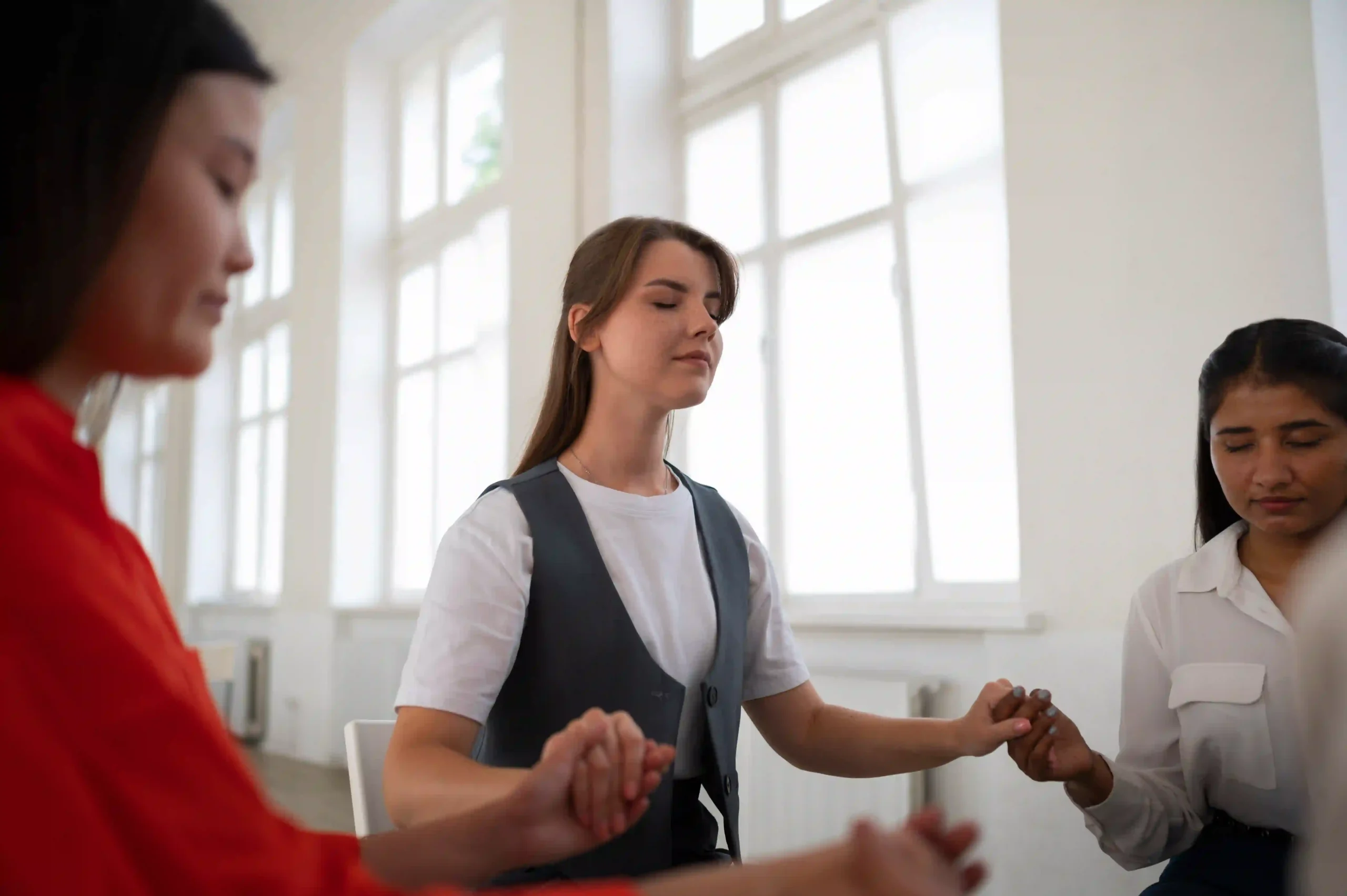 Young women holding hands in a spiritual support circle in Scottsdale 85262