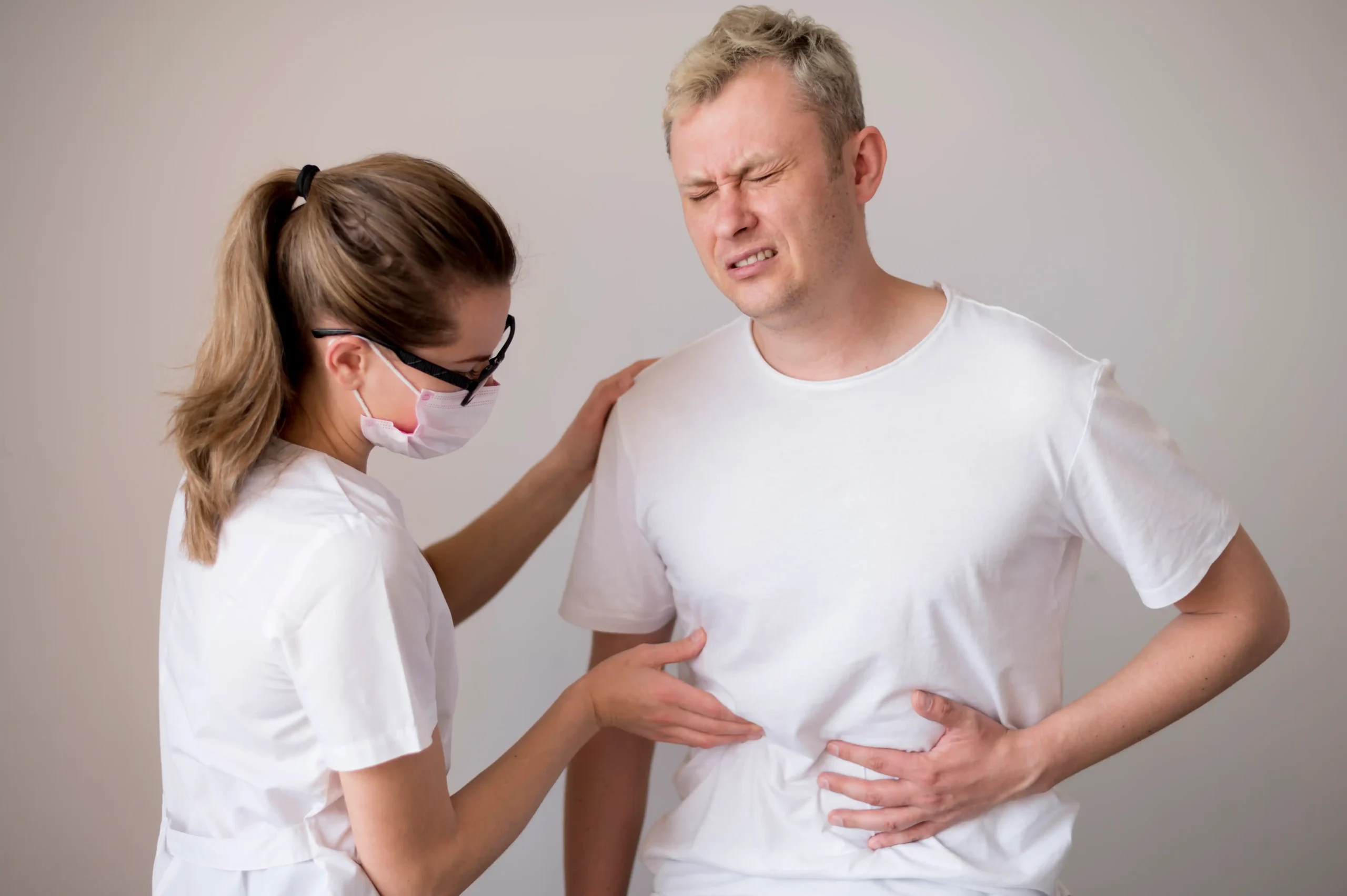 A healthcare provider examines a man with stomach pain, highlighting gastrointestinal testing supported by GTI Labs in 85262