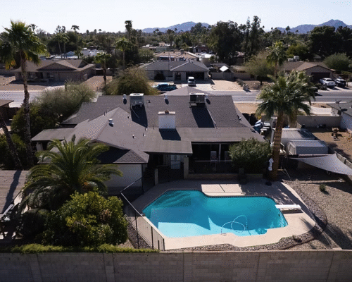 Aerial view of Agape Care Home in Scottsdale with a backyard pool, palm trees, and a covered patio.