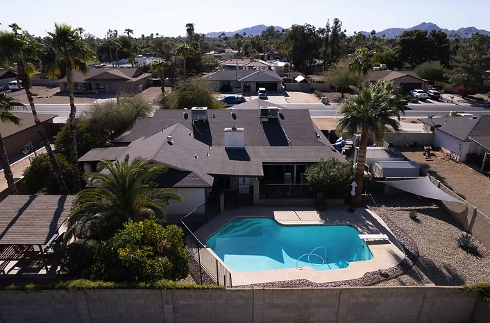 Aerial view of Agape Care Home in Scottsdale with a backyard pool, palm trees, and a covered patio.