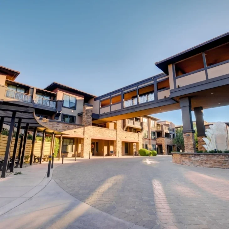 Entrance view of Andara Senior Living with elevated skybridge and stone architecture in Scottsdale