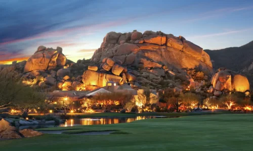 Scenic evening view of Boulders Resort & Spa Scottsdale with illuminated rock formations and desert landscape