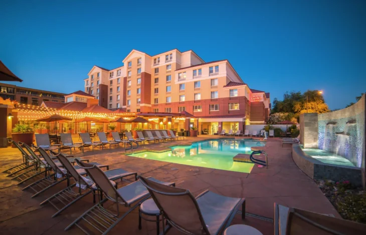 Outdoor pool with loungers and evening lights at Hilton Garden Inn Scottsdale Old Town