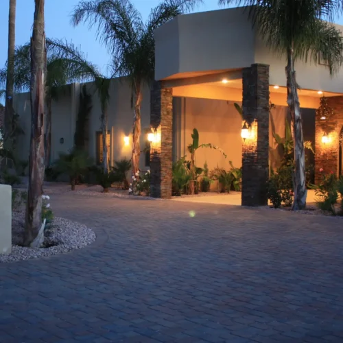 Exterior view of Arizona Royal Care Home senior living facility with evening lights and palm trees