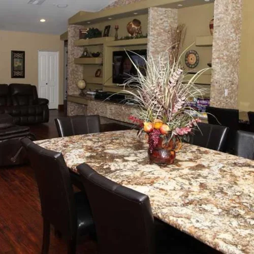 Spacious living and dining area inside Arizona Royal Care Home with granite table and leather seating