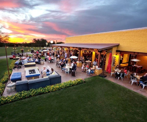 Isabella’s Kitchen patio at Grayhawk Golf Club during sunset, guests dining outdoors.