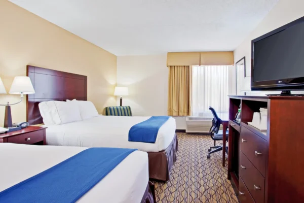 Standard double-queen guest room with modern furniture and warm lighting at Holiday Inn Express Scottsdale North.