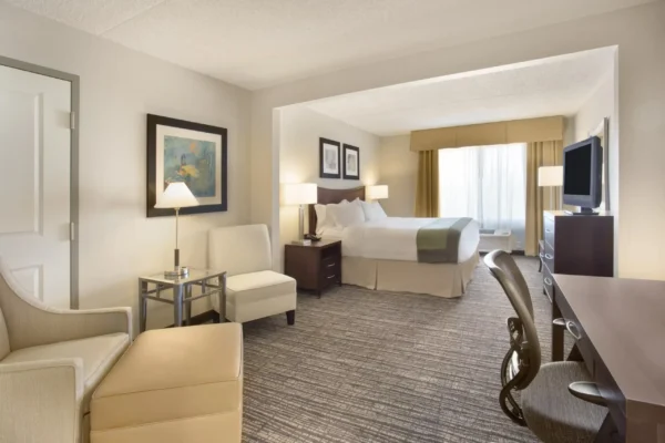 Spacious guest suite with king bed, work desk, lounge chair, and natural light at Holiday Inn Express Scottsdale North.