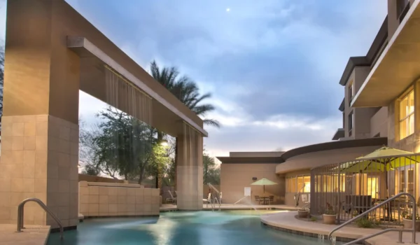 Outdoor heated pool with modern waterfall feature at Holiday Inn & Suites Scottsdale North – Airpark