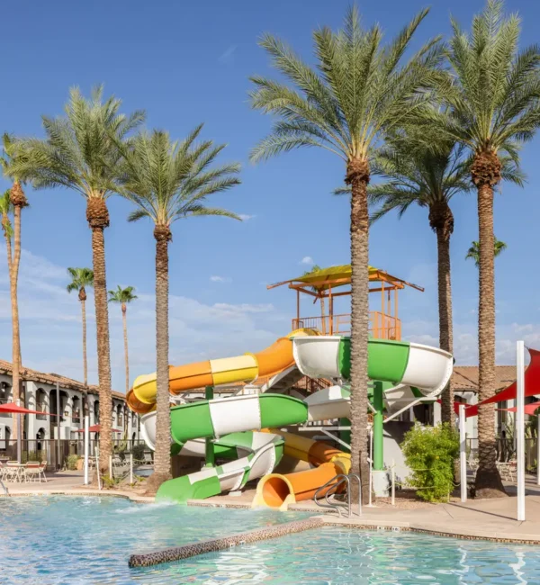 Resort pool area at Holiday Inn Club Vacations Scottsdale with colorful water slides and palm trees.