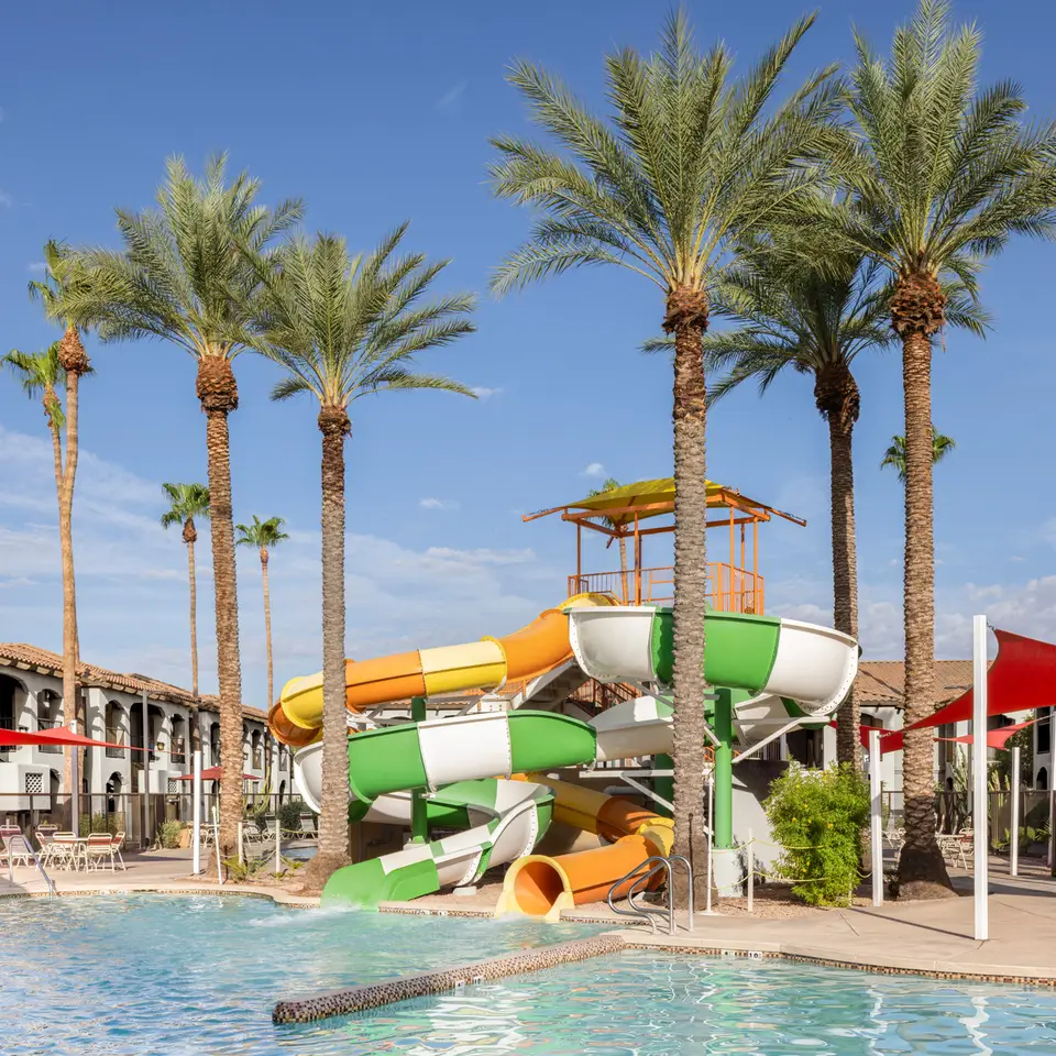 Resort pool area at Holiday Inn Club Vacations Scottsdale with colorful water slides and palm trees.