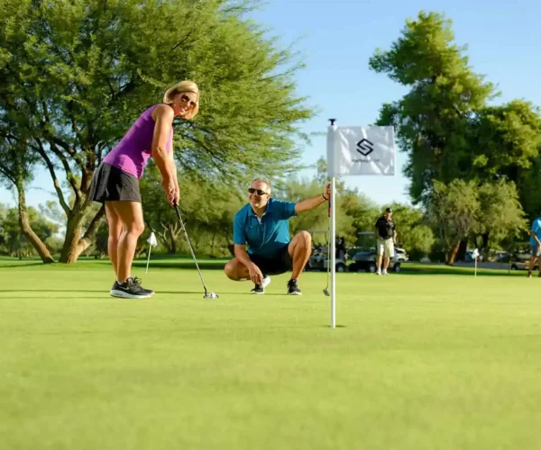 Woman practicing a short putt on the Starfire Golf Club green in Scottsdale