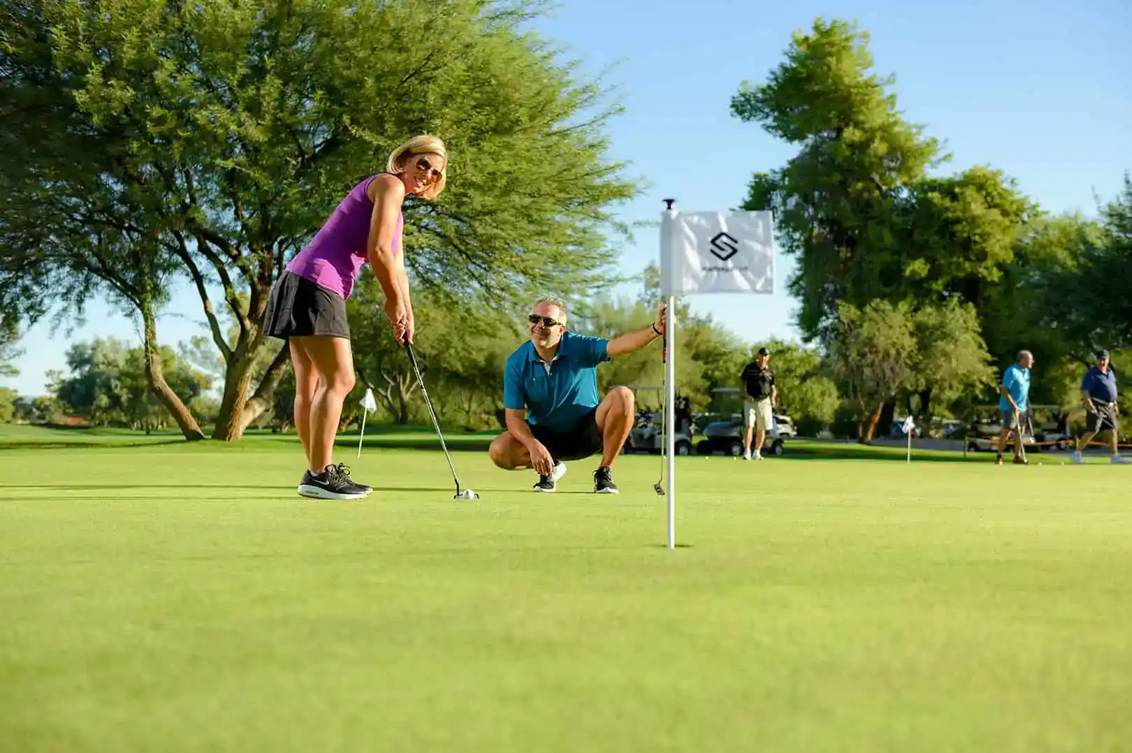 Woman practicing a short putt on the Starfire Golf Club green in Scottsdale