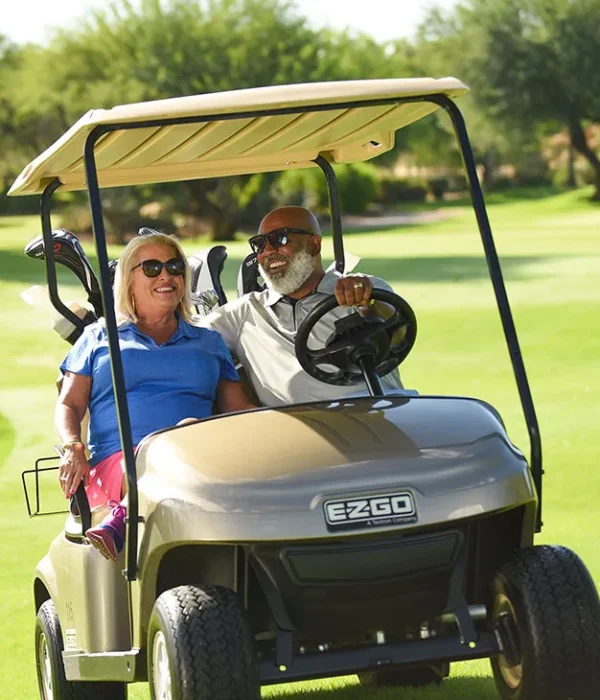 Smiling older couple riding a golf cart at Starfire Golf Club