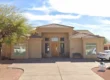 Exterior view of Bloomfield House assisted living facility at 9409 East Bloomfield, Scottsdale. A single-story beige stucco home featuring a tile roof, desert landscaping, and a welcoming entrance under a sunny Arizona sky