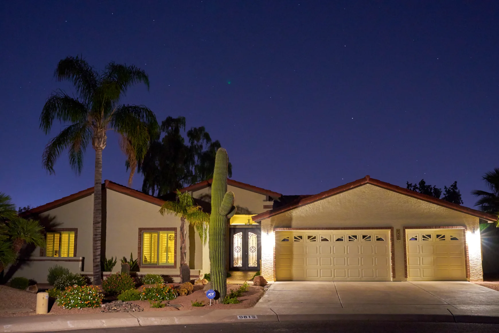 Exterior view of Blue Lakes Assisted Living residence at night with landscaped front yard and driveway