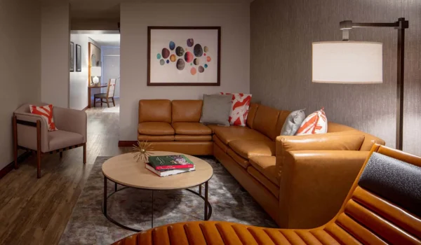 Spacious suite living area at Hotel Adeline with leather sectional sofa and modern decor